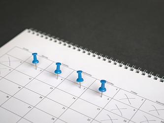Calendar showing blue pins on four days of the week, with other days crossed off in pen